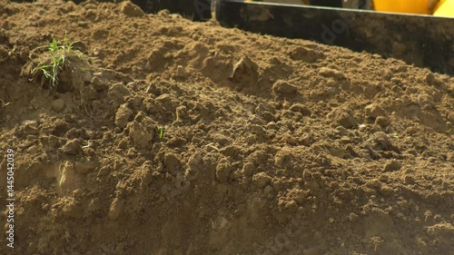 Tractor excavator collects soil in a bucket at a construction site. Construction, background, industry, bulldozer