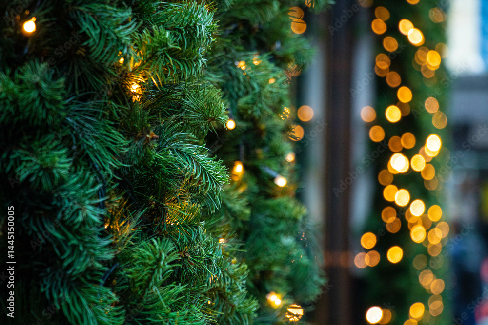 Christmas tree with luminous garland, with focus in the foreground and a blurred backdrop