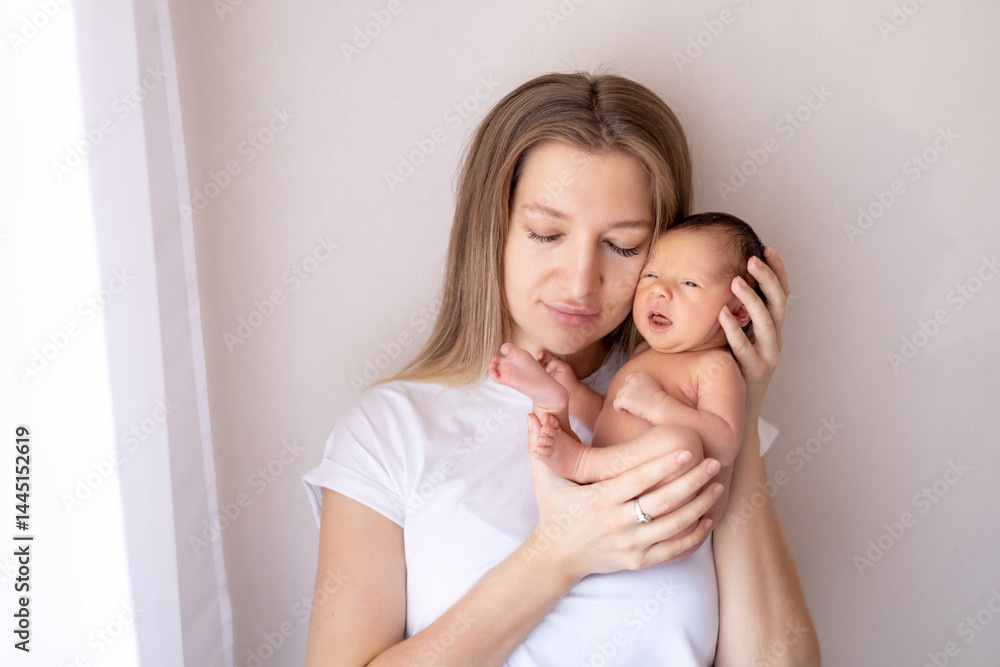 a mother with a newborn baby in her arms gently hugs and kisses him, a mother and a newborn baby in diapers, maternal love and care a mother with a newborn baby in her arms gently hugs and kisses him, a mother and a newborn baby in diapers, maternal love and care
