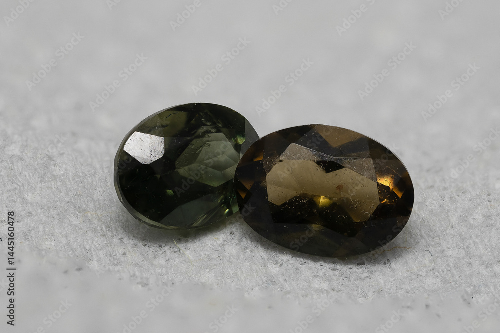 Close-Up View of Two Brilliant Cut Gemstones on Soft Gray Surface