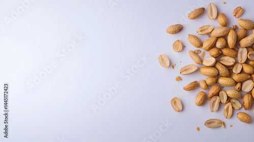 A Varied Collection of Shelled Peanuts Spread Across a Light Background With Soft Shadows