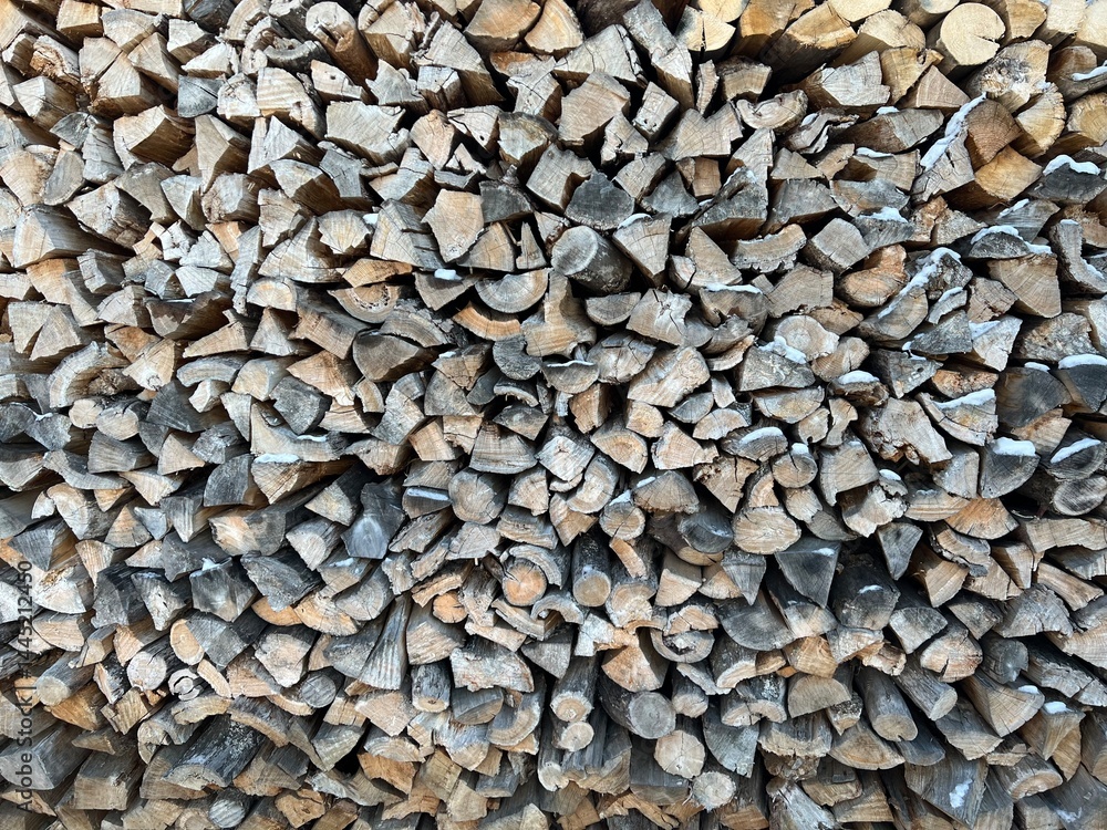 Firewood in the woodshed, preparation for the heating season in the village. Warm, brown colors, rustic style