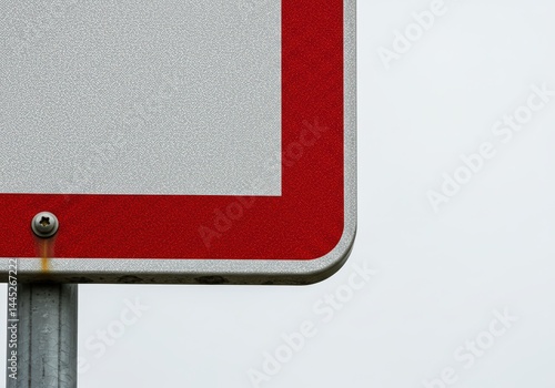 Obraz na płótnie Close up detailed abstract view of a street sign corner showing reflective silver and red materials on a metal post with a visible screw. w salonie