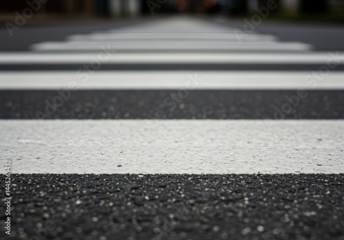 Crossroad marking stripes on asphalt for safe pedestrian crossing. Close up street view. Transportation and road safety concept. Urban environment traffic.
