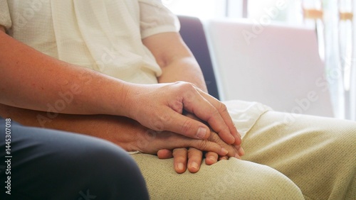 Photos An elderly woman sits anxiously holding her Sons's hand as she waits for a check-up at the hospital