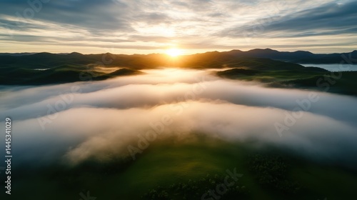 A breathtaking view of rolling hills shrouded in fog as the sun rises, showcasing the serene beauty and ephemeral nature of morning light in a lush landscape. photo