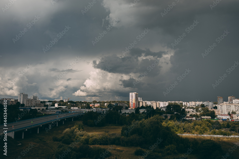 Naklejka premium Cloudy sky before rain. Clouds over houses and the city.