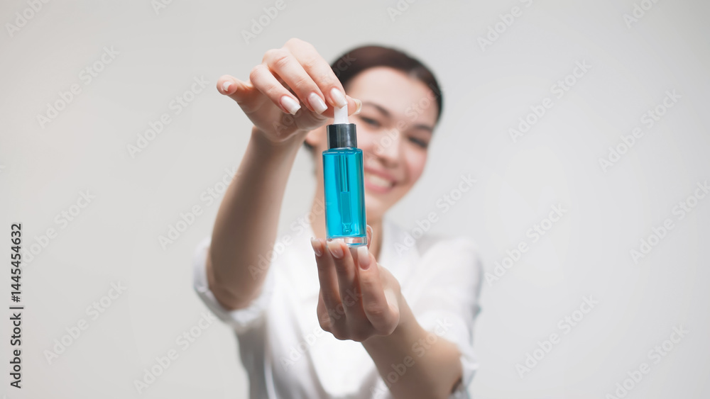 Beautiful woman with naturally clear and fresh skin, enjoying anti-aging collagen serum in her hands. Serum with active botanical ingredients vitamin C in a dropper. Beautiful woman with naturally clear and fresh skin, enjoying anti-aging collagen serum in her hands. Serum with active botanical ingredients vitamin C in a dropper.