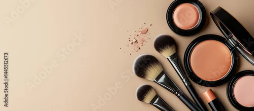Obraz Flat lay of professional makeup products and brushes on a beige background, representing beauty, cosmetics, and skincare branding with elegant simplicity