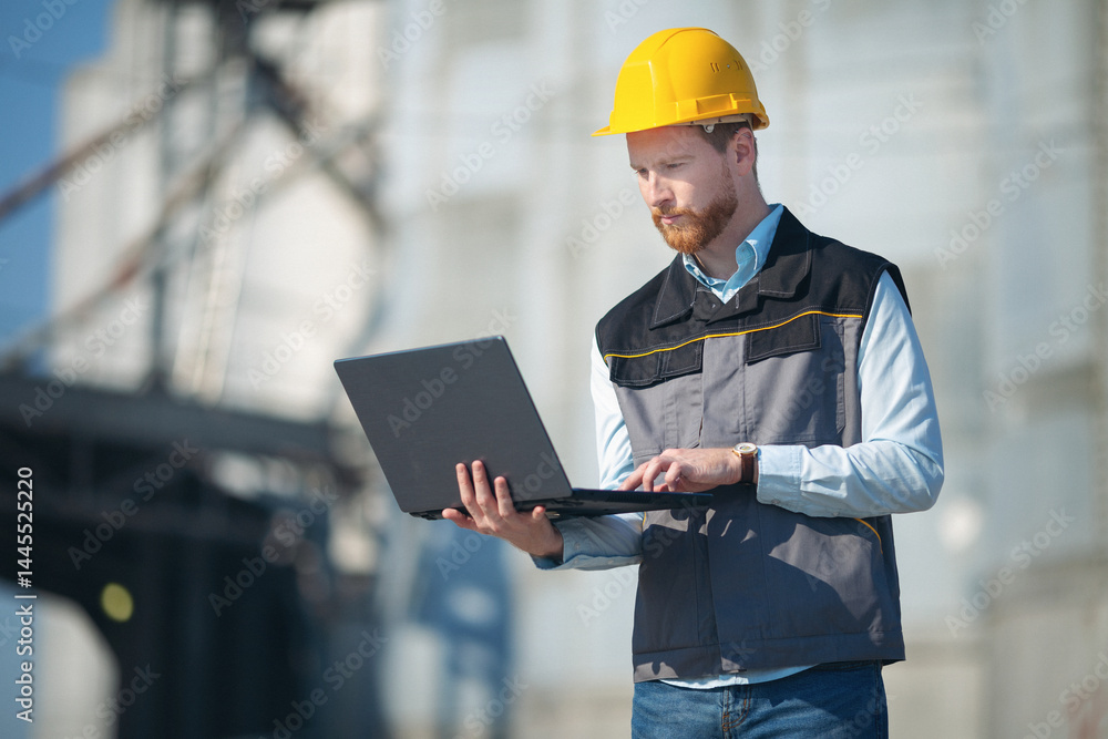 Manager in front of silo using technology Manager in front of silo using technology