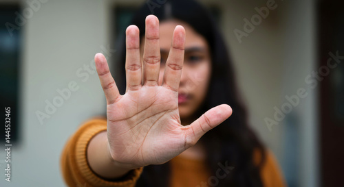 Woman hand showing stop gesture selective focus foreground blurred background warning signal. Selective focus hand, warning signal, stop concept.