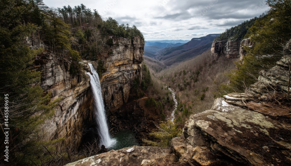 Obraz premium This cliff waterfall drops dramatically into the valley below, creating a stunning sight