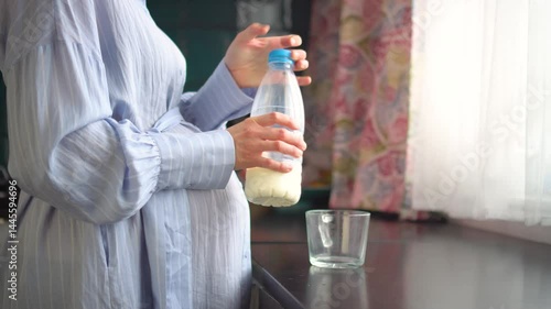 Mom-to-be savoring milk drink in peaceful home setting.