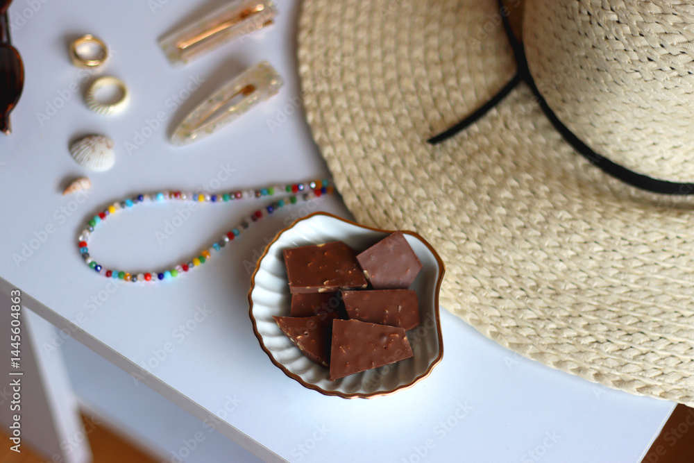Glass of cocktail, straw hat, sunglasses, books, fresh fruit, chocolate and accessories. Summer essentials on the table. Selective focus.