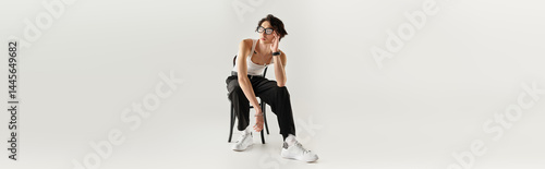 Stylish young man poses effortlessly in studio showcasing modern fashion trends