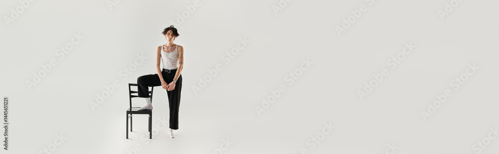 Stylish young man poses confidently in a minimalistic studio setting Stylish young man poses confidently in a minimalistic studio setting
