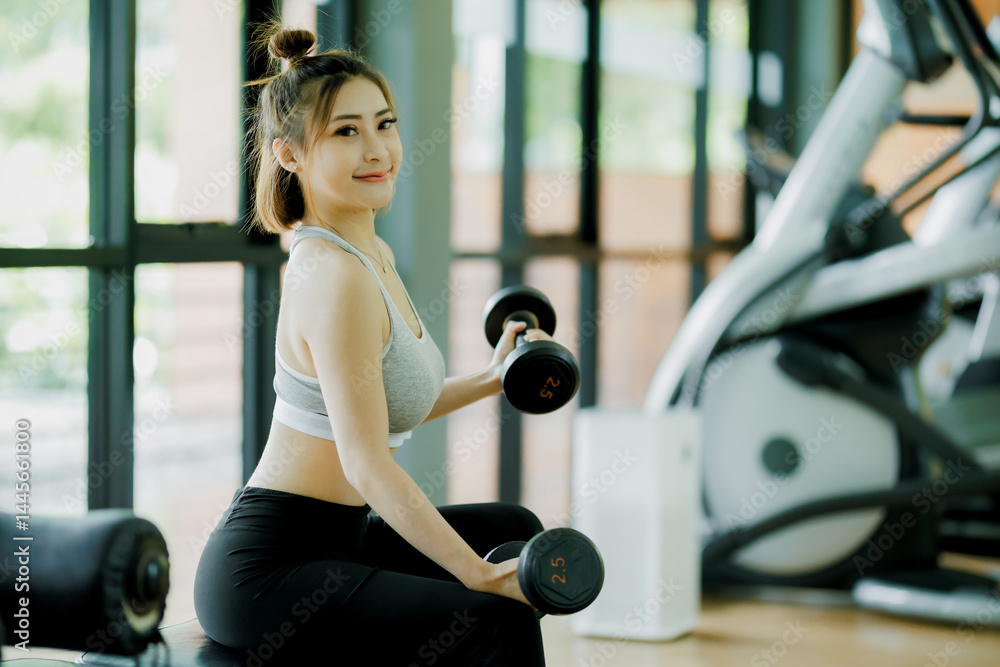 Obraz premium Confident woman lifting weights in a gym, representing strength, focus, and good health. Perfect for women's fitness and Canadian wellness content.