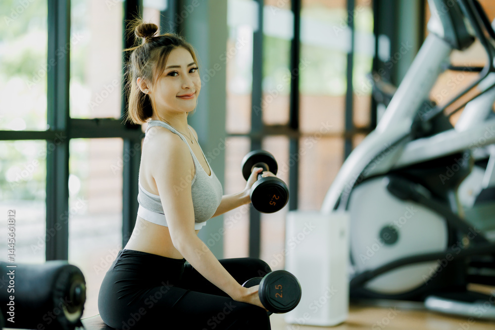 Fototapeta premium Confident woman lifting weights in a gym, representing strength, focus, and good health. Perfect for women's fitness and Canadian wellness content.