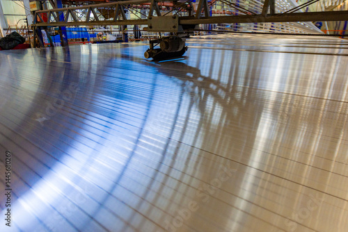 The aluminum products piled up in the warehouse of the aluminum factory, shining brightly under the light, form beautiful patterns