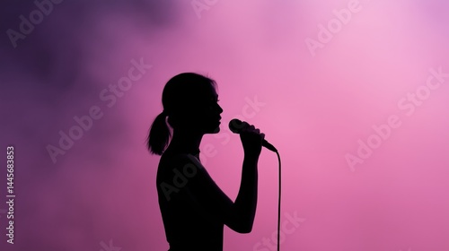 Obraz na płótnie Silhouette of a singer performing on stage with colorful lights in the background during a live music event at night. w salonie