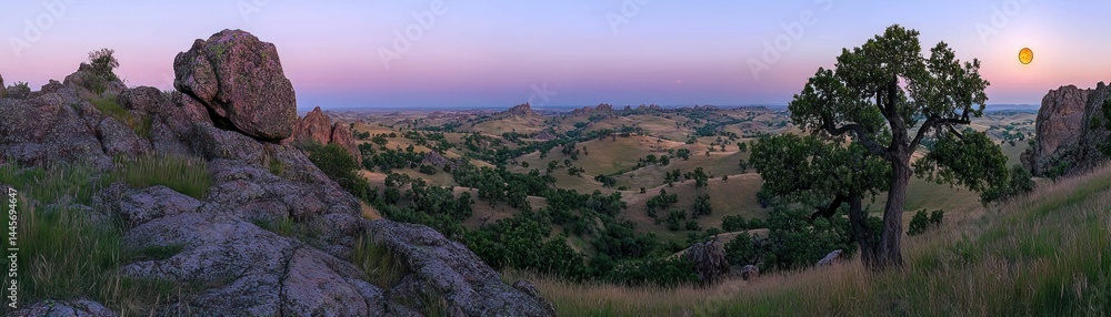Obraz premium Wide panoramic view of a hilly landscape at sunset time