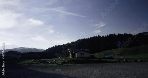 Small village in the Swiss Alps, showcasing stunning mountain views and charming architecture, suitable for travel brochures or website banners.