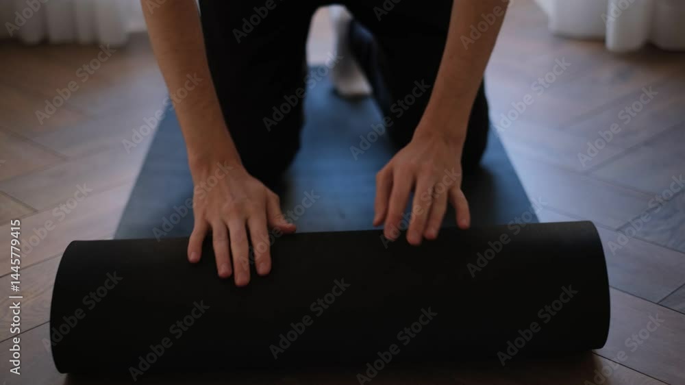 Young brunette lays out a sports mat for morning warm-up at home Young brunette lays out a sports mat for morning warm-up at home