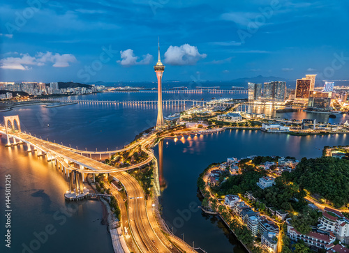 Obraz na plátne Illuminated cityscape with building and connecting bridges over the water at night in Macau