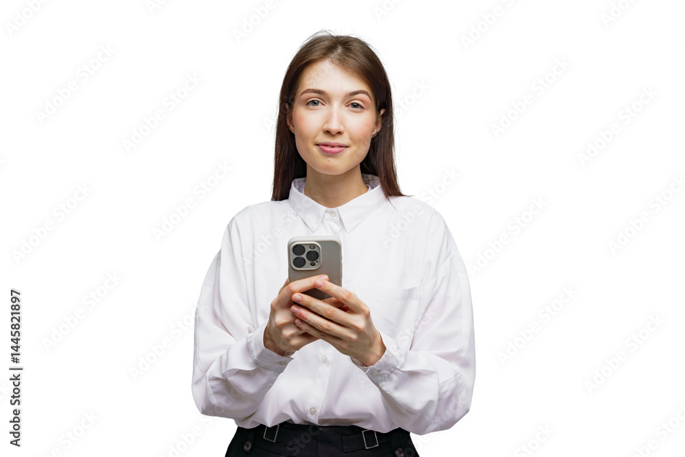 Young woman in casual attire smiles while holding her smartphone against a white background Young woman in casual attire smiles while holding her smartphone against a white background