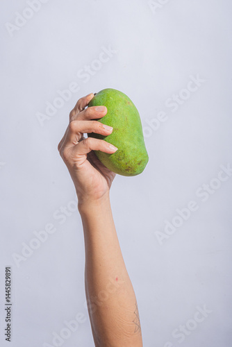 Hand holding a sliced mango with cubed yellow flesh facing outward against a bright white background, showing tropical freshness, juicy texture, and vibrant color of ripe exotic fruit.