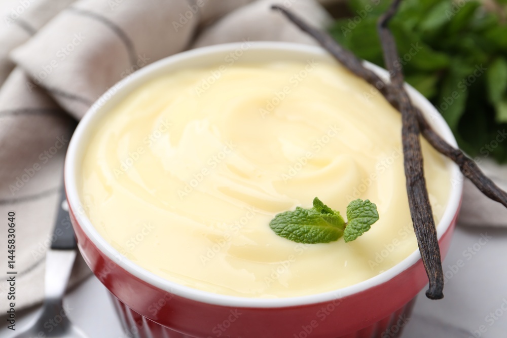 Tasty vanilla pudding, mint and pods on white table, closeup Tasty vanilla pudding, mint and pods on white table, closeup