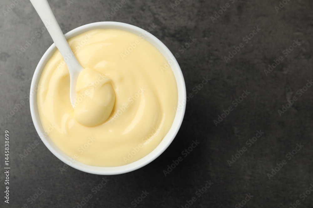 Tasty vanilla pudding with spoon on black table, top view. Space for text Tasty vanilla pudding with spoon on black table, top view. Space for text