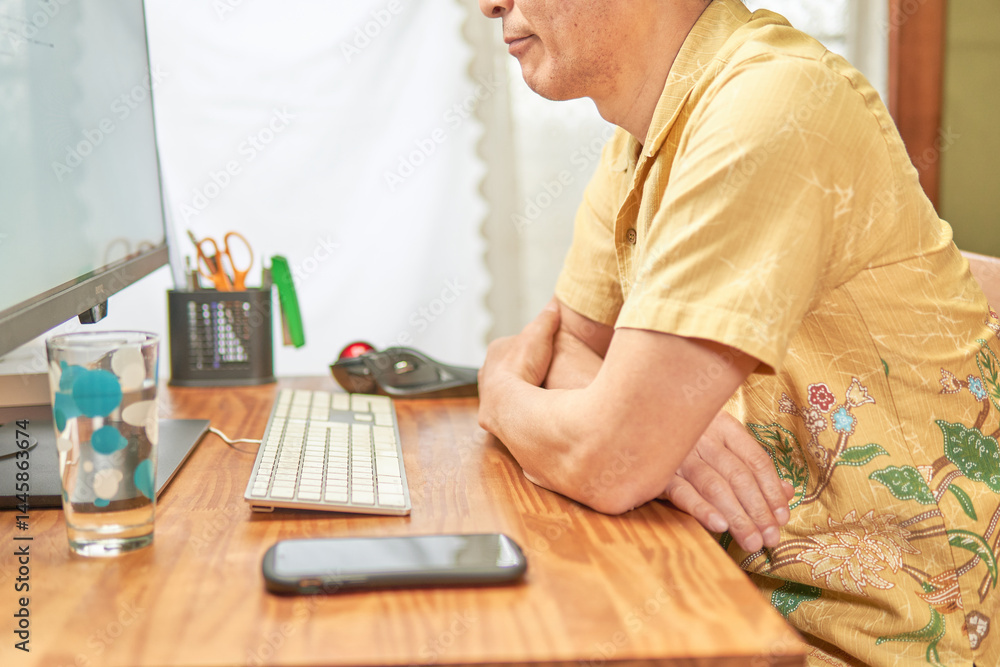パソコンの画面を見ながら考え込む男性 パソコンの画面を見ながら考え込む男性