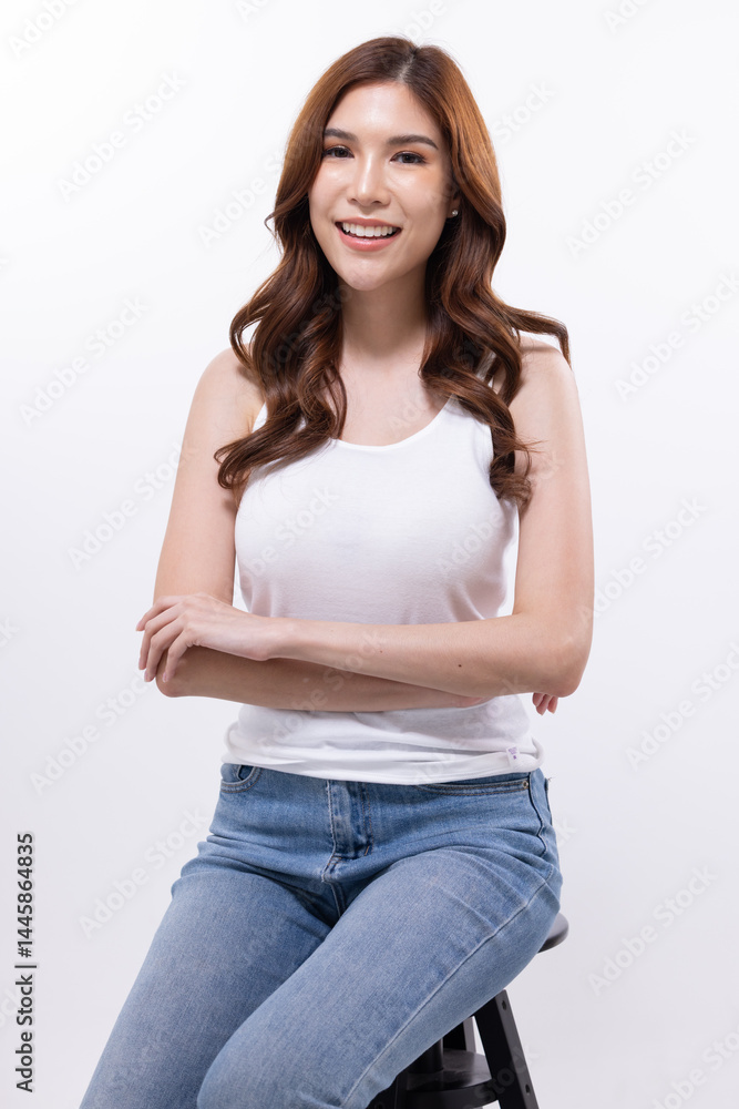 Fototapeta premium Smiling woman sitting on stool in casual outfit