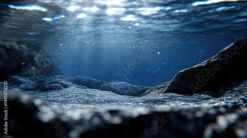 Deep underwater scene, sunlight beams through water.  Rocky seabed