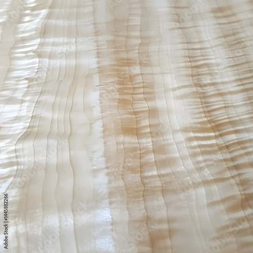 Close-up of figured maple wood grain texture with natural ripples and light golden tones for fine woodworking, luxury furniture, luthier material, interior design, veneer pattern, and timber surface

