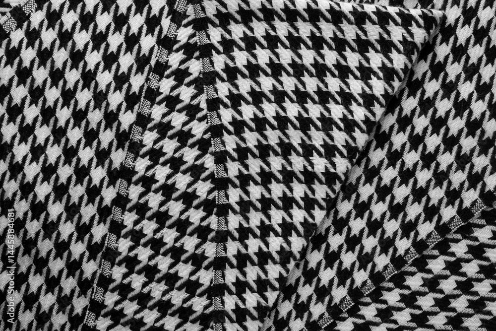 Close-up of black and white houndstooth scarf with visible folds and texture.