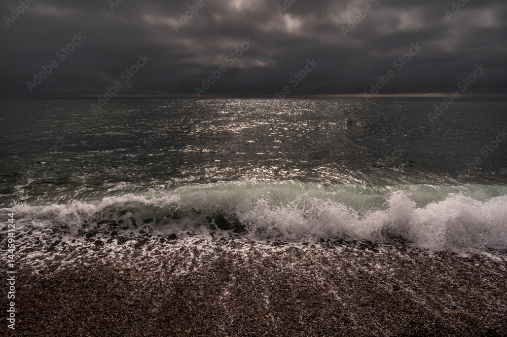 Dark storm clouds over ocean. Dramatic seascape. Clouds and rain flurry over sea.