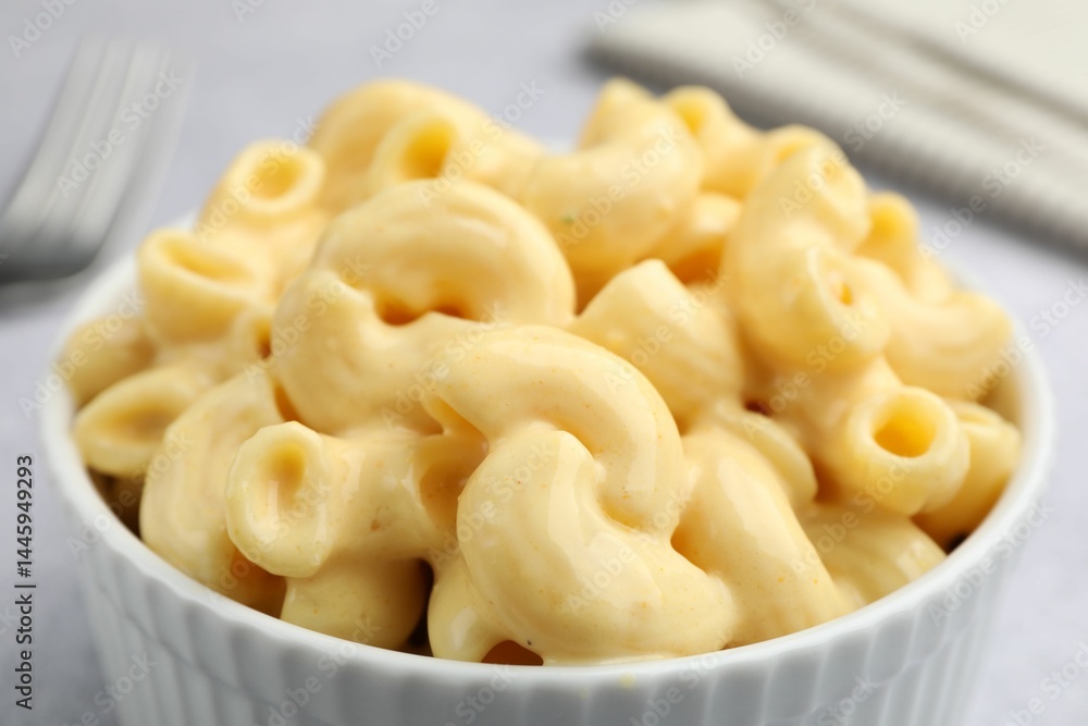 Delicious pasta with cheese sauce in bowl on table, closeup Delicious pasta with cheese sauce in bowl on table, closeup