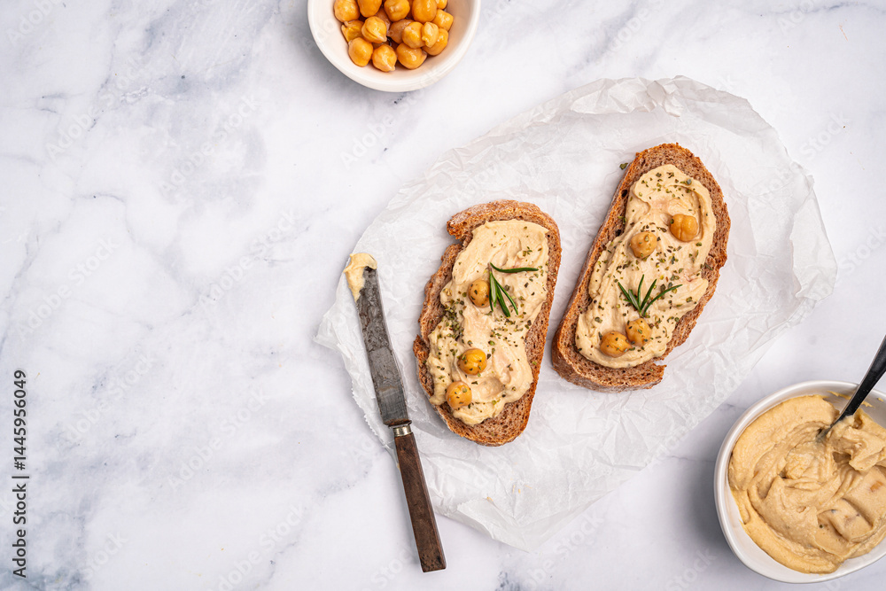 Delicious sandwiches with hummus and ingredients on white table, top view, flat lay. High quality photo