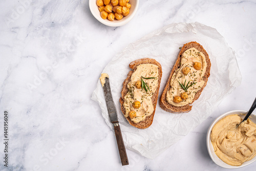 Obraz na płótnie Delicious sandwiches with hummus and ingredients on white table, top view, flat lay. High quality photo w salonie