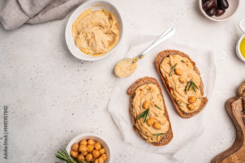 Delicious sandwiches with hummus and ingredients on white table, top view, flat lay. High quality photo