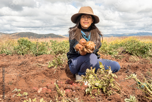 Photos latin girl holding freshly harvested potato in the bolivian andes, latin america