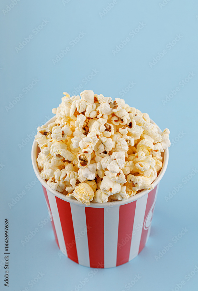 Classic red striped popcorn cardboard cup on blue background