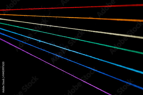 Obraz na płótnie multicolored sewing threads in the form of a rainbow on a black background w salonie