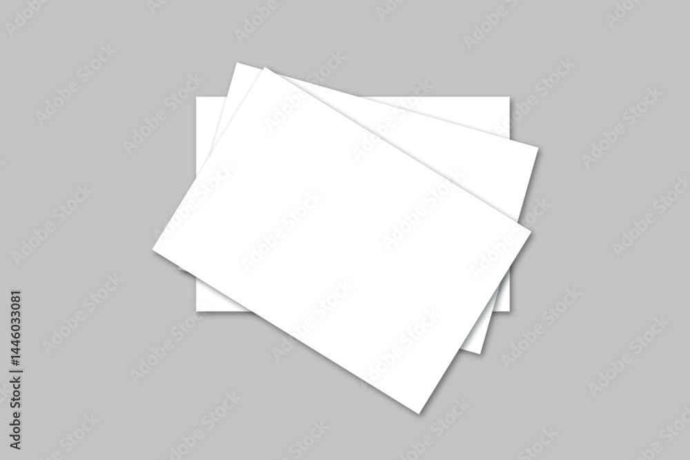 A top view of three white rectangular sheets of paper stacked on a gray surface in a studio shot A top view of three white rectangular sheets of paper stacked on a gray surface in a studio shot