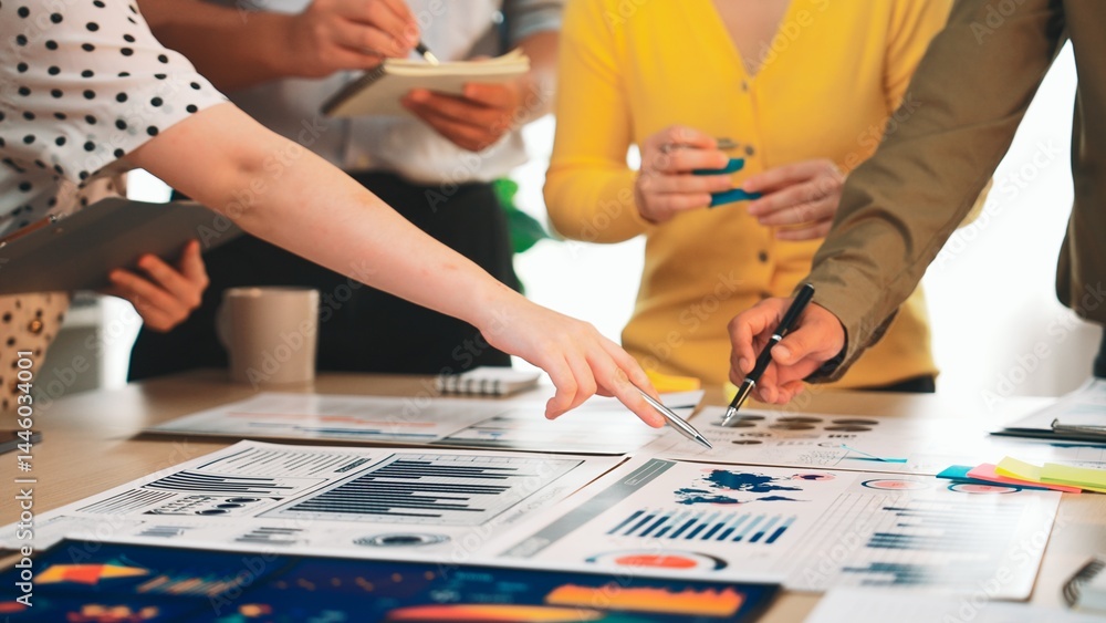 Obraz premium A dynamic team collaborates in a modern office setting, analyzing financial data and business reports through charts and graphs for informed decision-making and strategy. SACTR