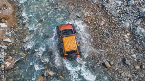 Elevated view of a vehicle navigating a rocky stream.