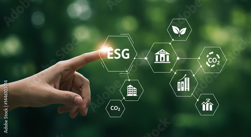 A hand touching esg icon with environmental and sustainability symbols on a green background