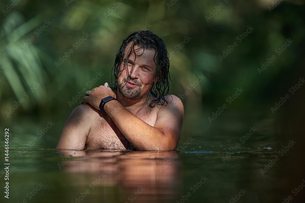 Man swimming in a small river in summer